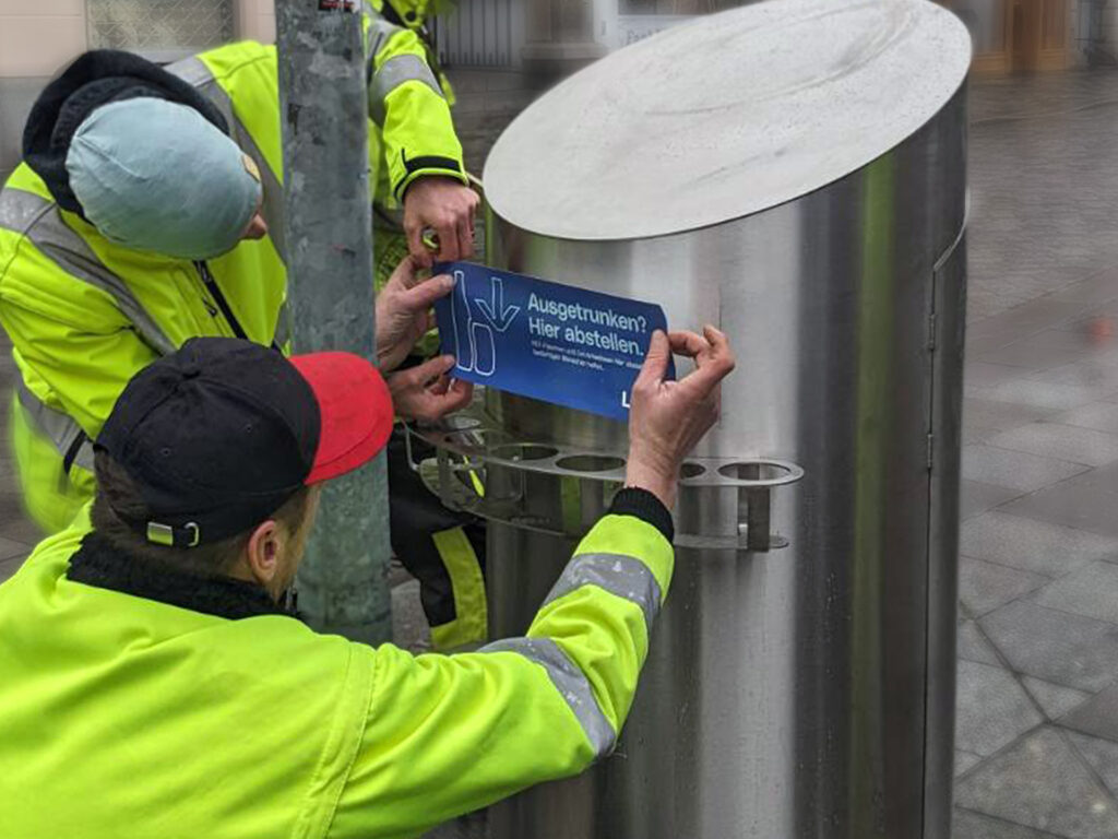 Pfandringe werden montiert, Aufkleber geklebt