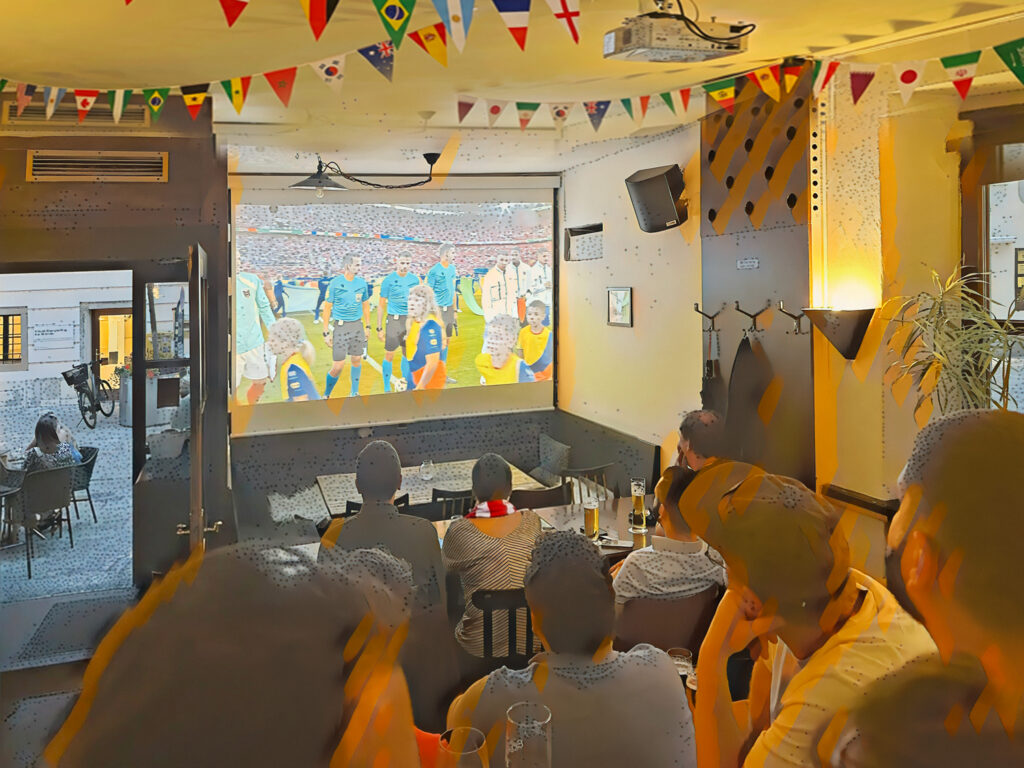 Symbolbild: gemeinsames WM-Schauen in einem Linzer Lokal. (Bild: Ahoi Linz; erstellt mit Unterstützung von KI)